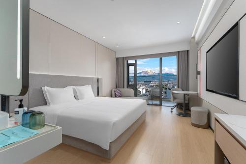 a hotel room with a bed and a television at Holiday Inn Express Lijiang Ancient Town by IHG in Lijiang