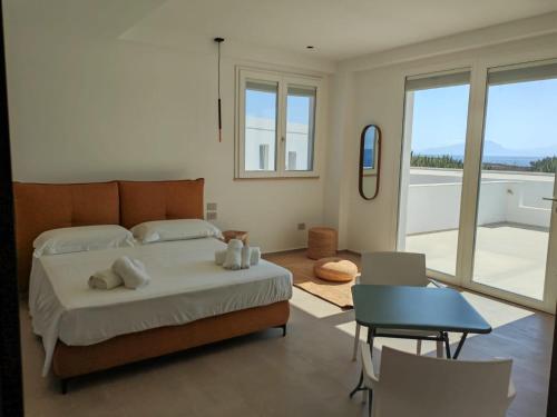 a bedroom with a bed and a view of a balcony at Dimora Cala Graziosa in Favignana