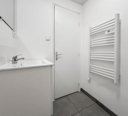 une salle de bain avec un lavabo et un réfrigérateur dans l'établissement CarlAppartement Elegance et Confort avec Wi-Fi & Parking II, à Carling