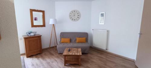 a living room with a couch and a table at Appartement T2 Vue montagne in Cauterets