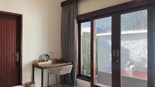 a room with a large window and a table with a table at KU Villas in Kuta Lombok
