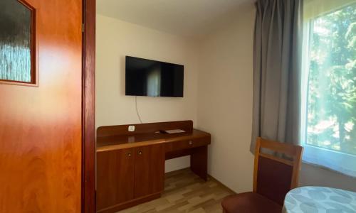 pokój z biurkiem i telewizorem na ścianie w obiekcie City Hostel w Szczecinie