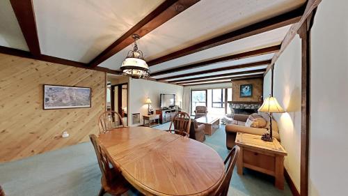 a dining room with a table and a living room at Retro 3 Bed 3 Bath Condo with Mountain View! Steps to Canyon Lodge! Unit 210 at 1849 in Mammoth Lakes