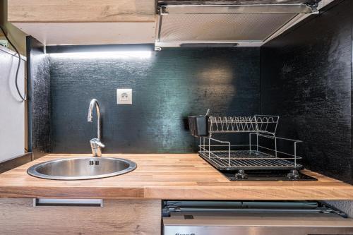 a kitchen with a sink and a black wall at Appartement spa fleures d'Orelle in Orelle
