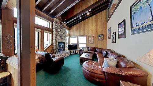 a living room with leather couches and a tv at Beautifully Remodeled 4 Bedroom Condo in Mammoth Lakes
