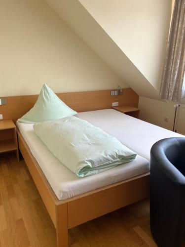 a bed with white sheets and a pillow on it at Hotel-Restaurant Jägerhof in Reinsfeld