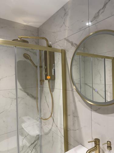a shower in a bathroom with a mirror at Murraygate Townhouse in Dundee