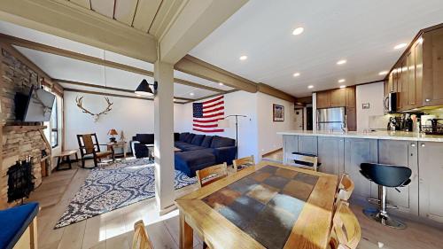 马姆莫斯湖Remodeled 2 Bedroom Condo with Amazing Views!的一间厨房和客厅,客厅内配有桌子