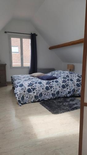 a bedroom with a bed with a blue and white blanket at "Les barbiots" Jolie dépendance proche plages in Offranville