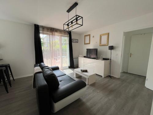 un salon avec un canapé et une télévision dans l'établissement Appartement 2 pièces terrasse Magny le Hongre, à Magny-le-Hongre