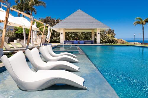 a swimming pool with white chairs next to a swimming pool at HOKU LANI HOUSE Heated Private Pool Spa Intro Pricing 25% off in Waimea