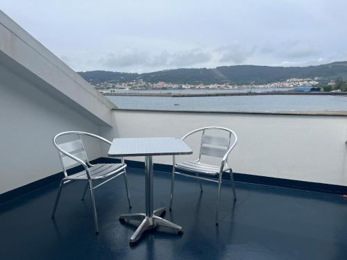 two chairs and a table on a balcony at Casa Flor de Lis in Cee