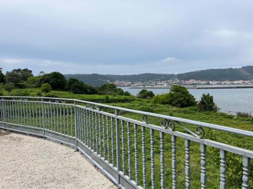 una recinzione metallica accanto a un corpo idrico di Casa Flor de Lis a Cee