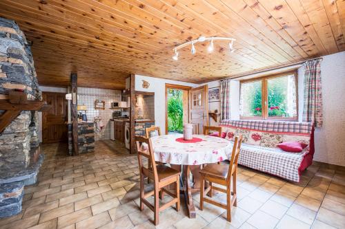 une salle à manger avec une table, des chaises et un canapé dans l'établissement Gîte montagnard Savoyard, à Bramans