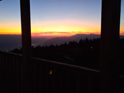 une vue d'un coucher de soleil depuis un balcon dans l'établissement Résidence l'Ecrin des Neiges, à Chamrousse