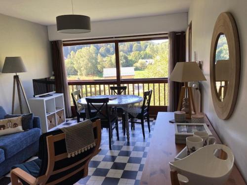 un salon avec un canapé bleu et une table dans l'établissement Grand 2P, balcon sud, local vélo, Villard-de-Lans - FR-1-689-133, à Villard-de-Lans