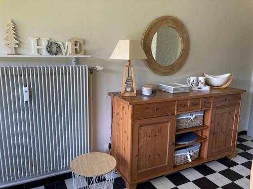 une pièce avec une commode en bois avec une lampe et un radiateur dans l'établissement Grand 2P, balcon sud, local vélo, Villard-de-Lans - FR-1-689-133, à Villard-de-Lans