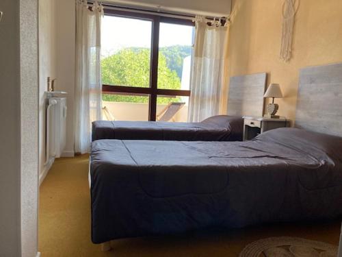 une chambre avec deux lits et une grande fenêtre dans l'établissement Grand 2P, balcon sud, local vélo, Villard-de-Lans - FR-1-689-133, à Villard-de-Lans