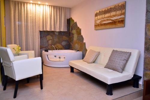 a living room with a couch and a bath tub at Hotel Konaki in Arnaia