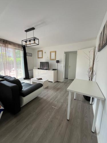 un salon avec un canapé et une table dans l'établissement Appartement 2 pièces terrasse Magny le Hongre, à Magny-le-Hongre