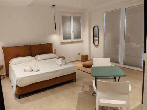 a bedroom with a bed and a table and chairs at Dimora Cala Graziosa in Favignana