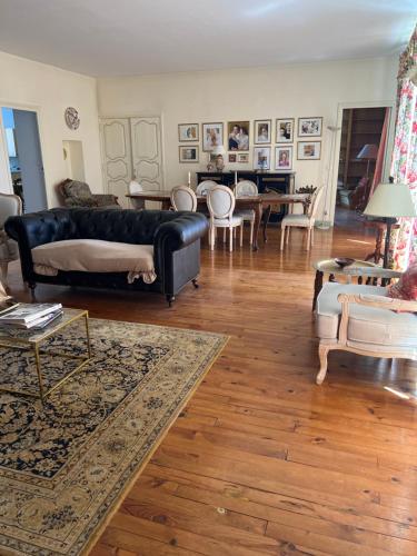 a living room with a black couch and a table at Le Chalet in Coulmier-le-Sec