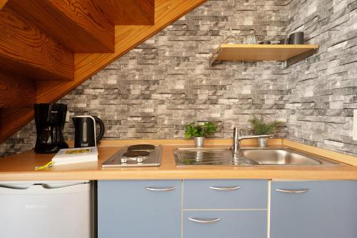 a kitchen with a sink and a brick wall at Gästehaus Sulsdorf Wohnung 18 in Sulsdorf auf Fehmarn