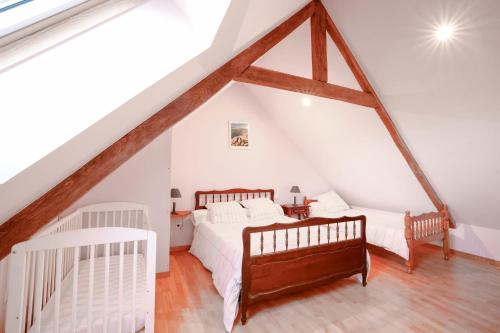 - une chambre mansardée avec 2 lits et un escalier dans l'établissement Gite Triskel, à Cast