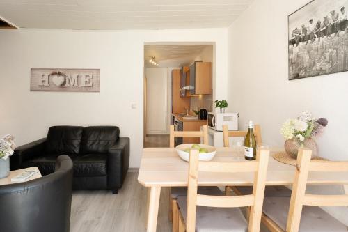 a living room with a table and a couch at Gästehaus Sulsdorf Wohnung 9 in Sulsdorf auf Fehmarn