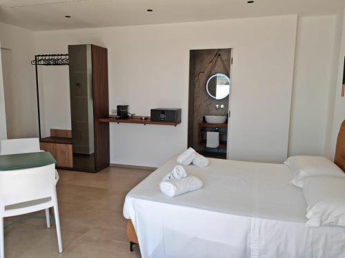 a bedroom with a white bed and a chair at Dimora Cala Graziosa in Favignana