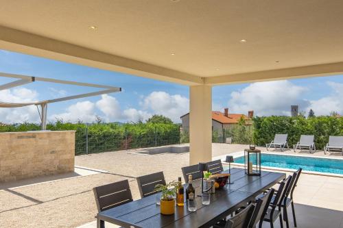 Villa Ivona di San Lorenzo Private Pool - Happy Rentals في Sveti Lovreč Pazenatički: فناء مع طاولة وكراسي وحمام سباحة