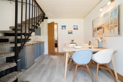 a kitchen and dining room with a table and chairs at Gästehaus Sulsdorf Wohnung 20 in Sulsdorf auf Fehmarn