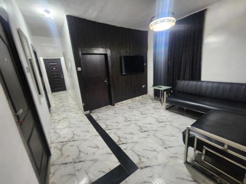 a lobby with a couch and a television in a building at CG Apartments Metro in Ikeja