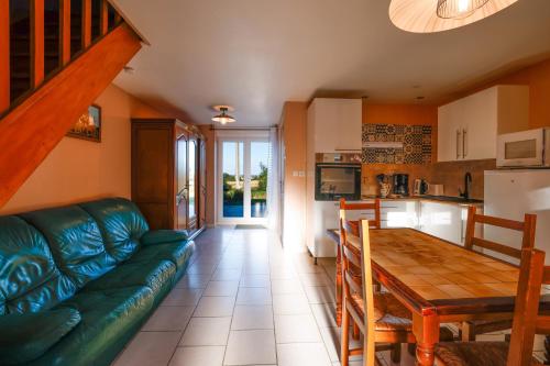 un salon avec un canapé vert et une table dans l'établissement Gite Triskel, à Cast