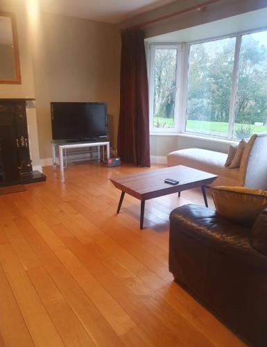 a living room with a couch and a coffee table at Tigh Dawros - Charming 4-bedroom house with WiFi in beautiful Kenmare, Kerry in Dinish Island