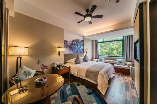 嘉善Luoxingge SSAW Boutiquel Hotel的带床和吊扇的卧室