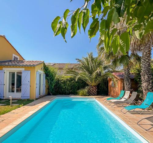 une piscine avec deux chaises et une maison dans l'établissement Maison spacieuse, piscine parking privé & jardin, à Castries