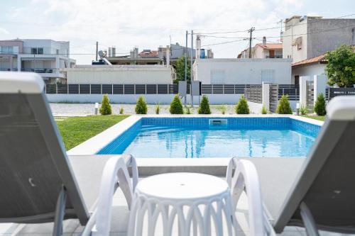 a view of a swimming pool with chairs and a table at Nefeli & Nefeli Luxury Residential Complexes in Ofrínion
