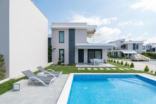a villa with a swimming pool and a house at Nefeli & Nefeli Luxury Residential Complexes in Ofrínion