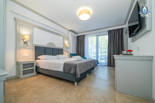 a hotel room with a bed and a television at Daria Boutique Hotel in Eforie Sud