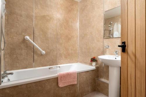 a bathroom with a bath tub and a sink at Harvest Cottage in Bridlington