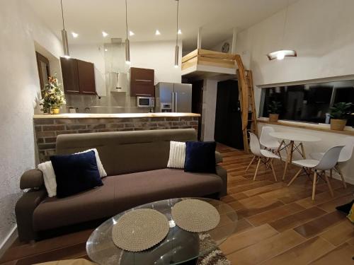 ein Wohnzimmer mit Couch und Tisch in der Unterkunft Domek Loft z Balią Jacuzzi i sauną na wyłączność Dowspuda 