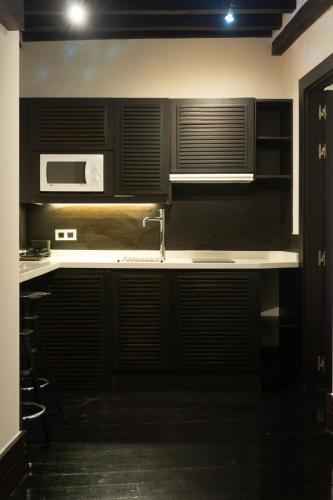 a kitchen with a sink and a microwave at La Plaza in Hervás