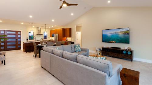 a living room with a couch and a dining room at ALOHA SHORES Spacious Ainamalu 4BR Home with Mountain and Ocean View in Waikoloa