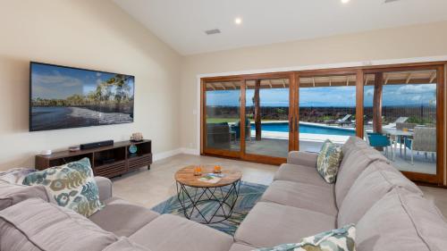a living room with a couch and a table at ALOHA SHORES Spacious Ainamalu 4BR Home with Mountain and Ocean View in Waikoloa