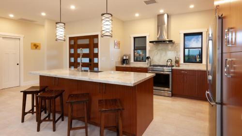 a kitchen with a large island with bar stools at ALOHA SHORES Spacious Ainamalu 4BR Home with Mountain and Ocean View in Waikoloa