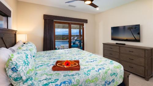 a bedroom with a bed with a television and a dresser at ALOHA SHORES Spacious Ainamalu 4BR Home with Mountain and Ocean View in Waikoloa