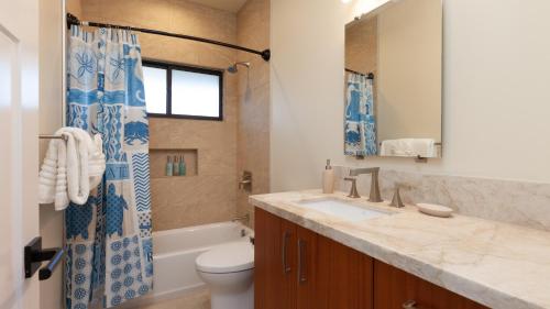 a bathroom with a sink and a toilet at ALOHA SHORES Spacious Ainamalu 4BR Home with Mountain and Ocean View in Waikoloa