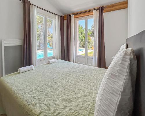 une chambre avec un grand lit avec une grande fenêtre dans l'établissement Maison spacieuse, piscine parking privé & jardin, à Castries