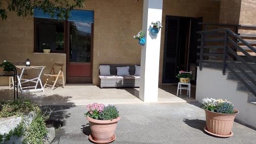 a patio with two potted plants in front of a building at Casa BOUGANVILLE in Cocumola